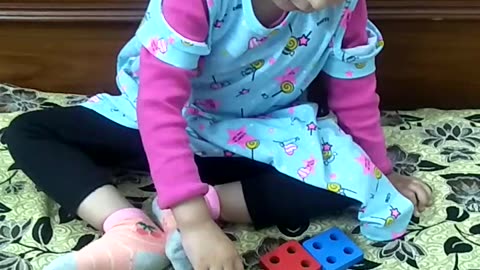 Two and half years old intelligent girl playing with her grandfather intelligently