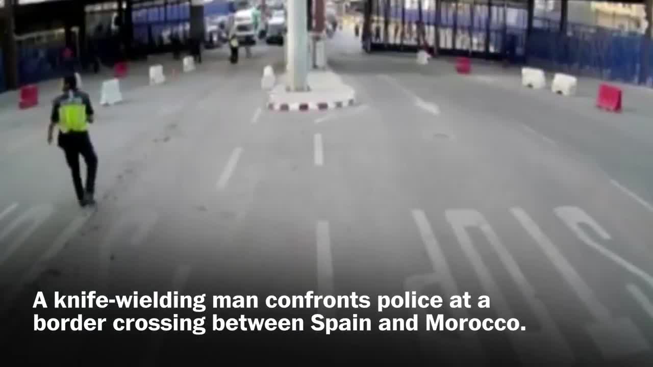 Spanish police throw traffic barrier at knife-wielding man