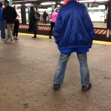 Blue jacket man dances in subway