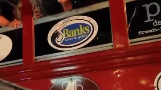 Car with head out of bus with cup talking to guy yells starbucks