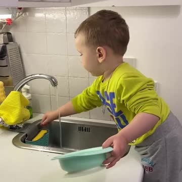 The guy washes the plate behind him