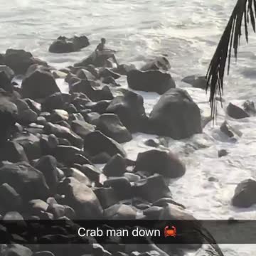 Guy on top of rocks gets splashed by waves