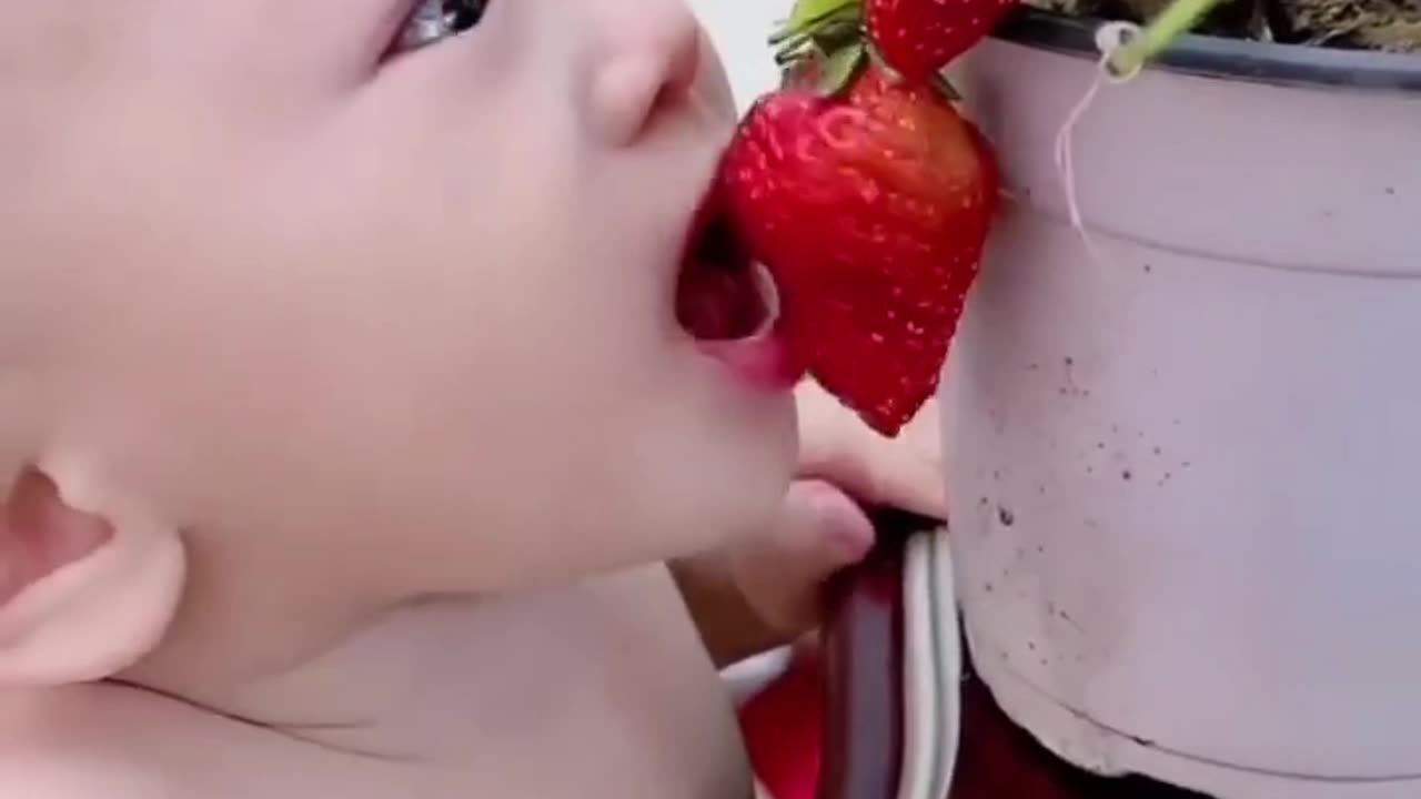 Baby standing on the table.eating strabary