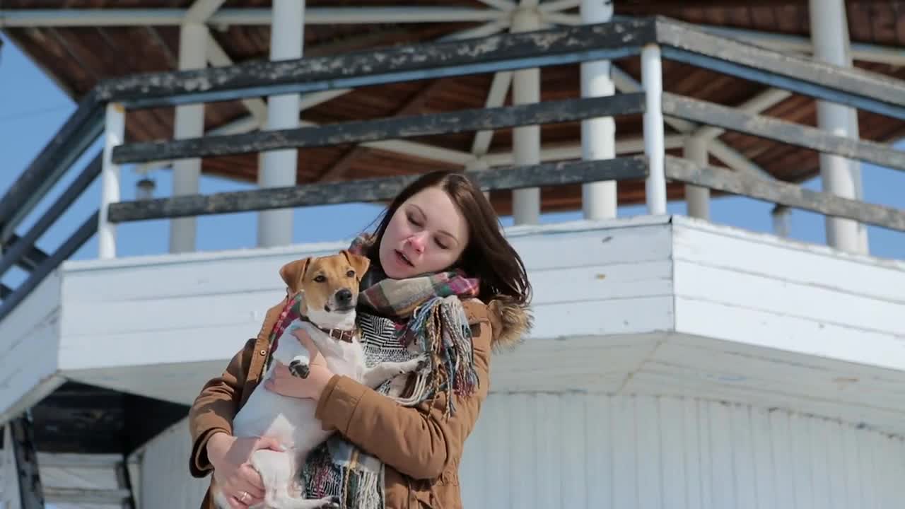 The girl with the dog on the background of the lighthouse