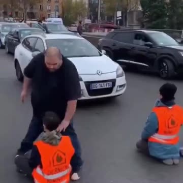 Man removes protestors blocking traffic.