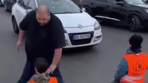 Man removes protestors blocking traffic.