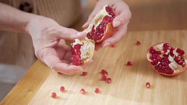 Elderly Woman Opening a Pomegranate