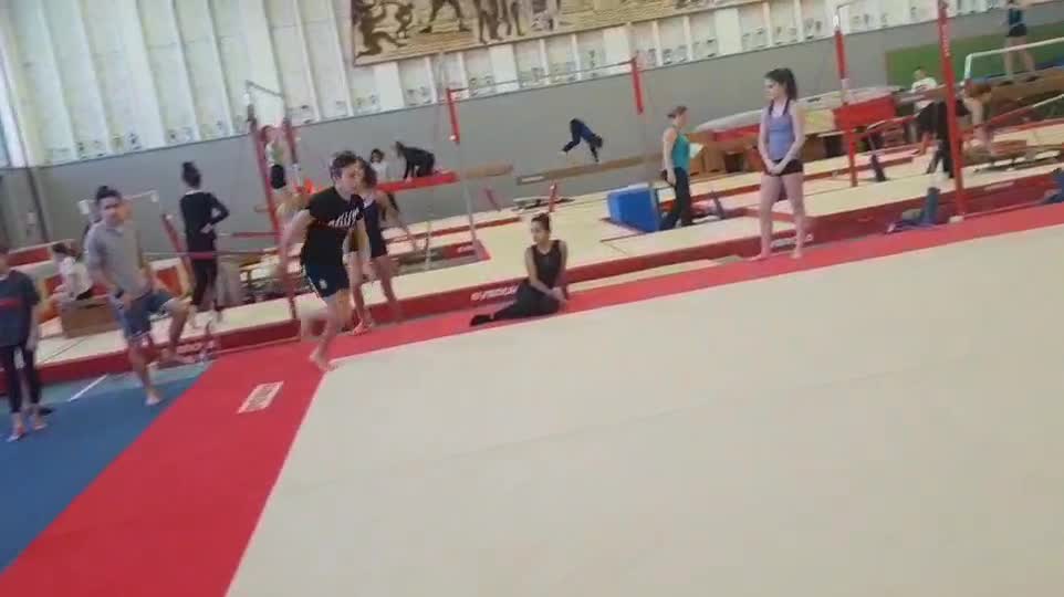 Gymnast does a flip on platform and falls, laughs