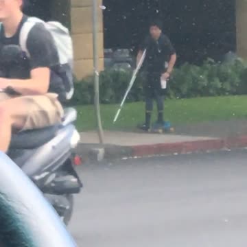 Guy in black shirt skating with broken leg
