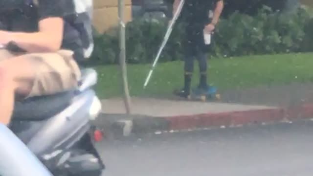 Guy in black shirt skating with broken leg