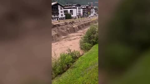 Raging muddy water carry cars through Austrian ski resort.mp4