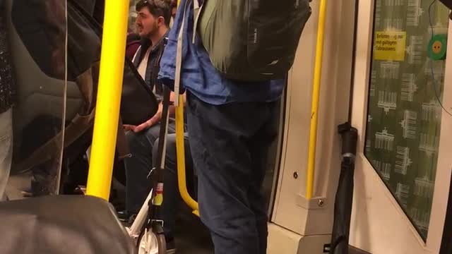 Man in blue plays flute on subway