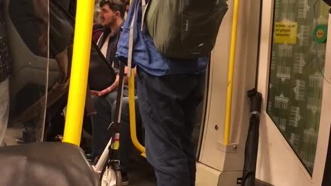 Man in blue plays flute on subway