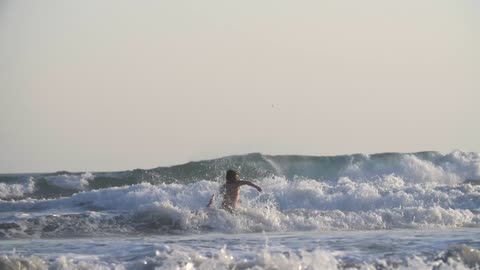 Surfer Walking Through Large Waves