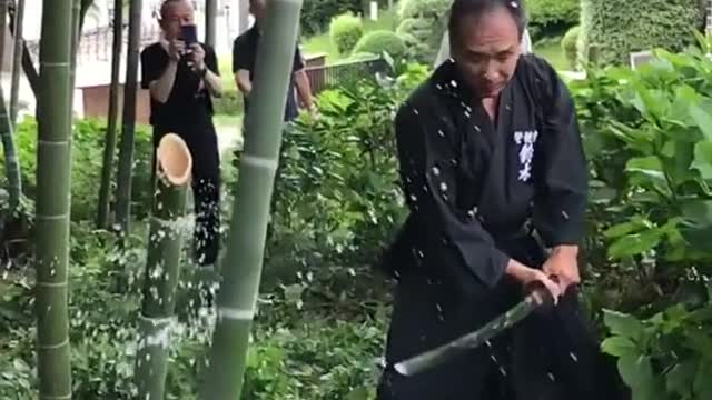 The man is cutting to the bamboo katana cut that cleanly