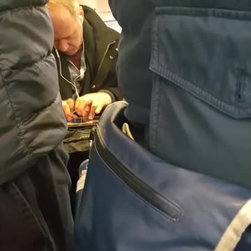 Man plays guitar on his ipad on subway