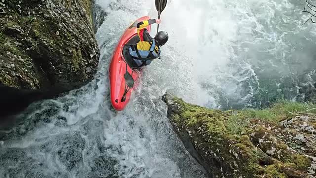 SLO -MO Rider in a yellow whitewater kayak dropping a waterfall stock video