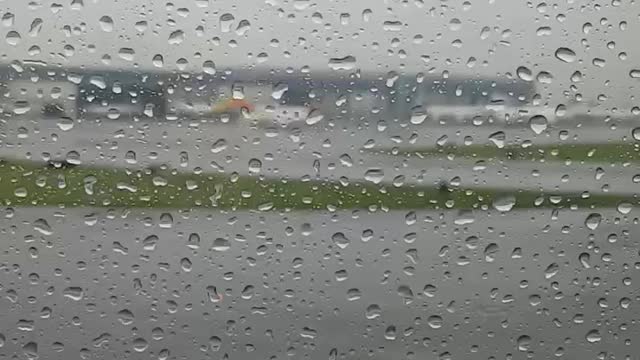 Rainy airport. Raindrops on the plane windows. Between the clouds. Time Labs.