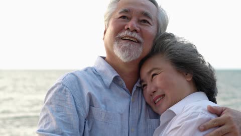 Elder Couple Hug At Seaside