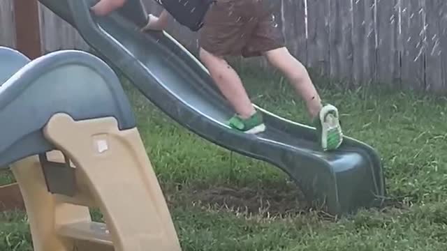 Kid Tries Climbing up Wet Slide