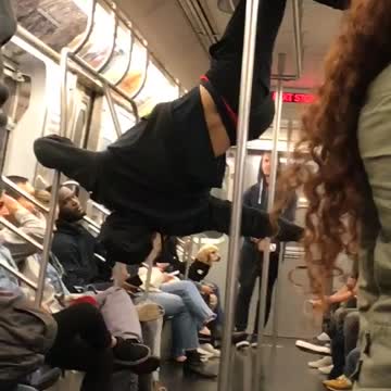 Man in black outfit dancing on train