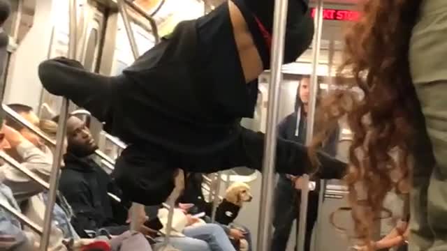 Man in black outfit dancing on train