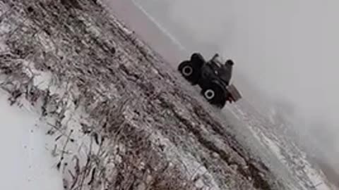 Man flips over on green snow mobile