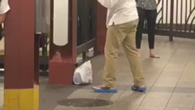 Guy long white shirt punching sign on wall