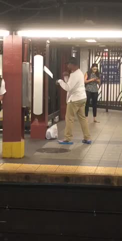 Guy long white shirt punching sign on wall