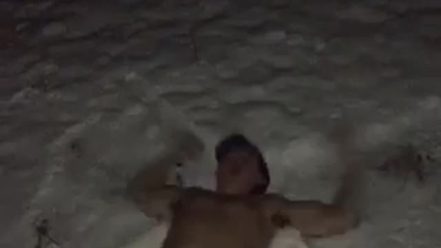 Guy in hat and underwear shot guns beer and then makes snow angels