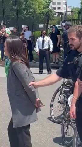 AOC Attempts To Fool Us All, Acts Like She's Handcuffed In Bizarre Stunt