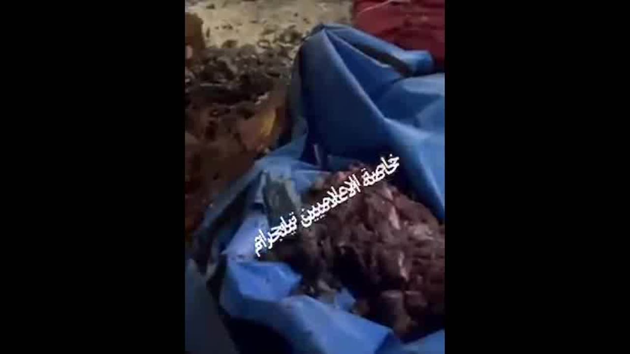 Israel Bombs School. Body parts collected in blue tarp