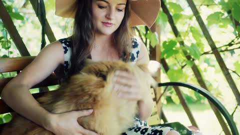 Pretty girl playing with dog in the arbor, steadycam shot