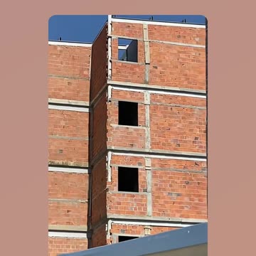 Bricklayer makes structural columns in building using PVC pipe