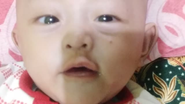 the baby is playing with saliva in the spray
