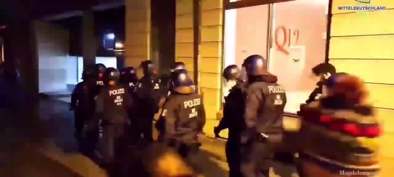 In Magdeburg, a police officer elbows a walker for no reason at all.