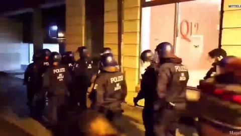 In Magdeburg, a police officer elbows a walker for no reason at all.