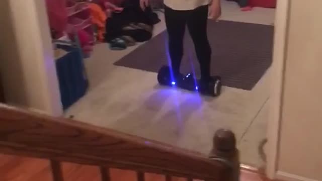 White shirt woman falls off hoverboard in front of stairs