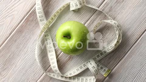 Green apple and measuring tape on table