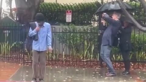 Tall geyser shoots water over multi-story building.