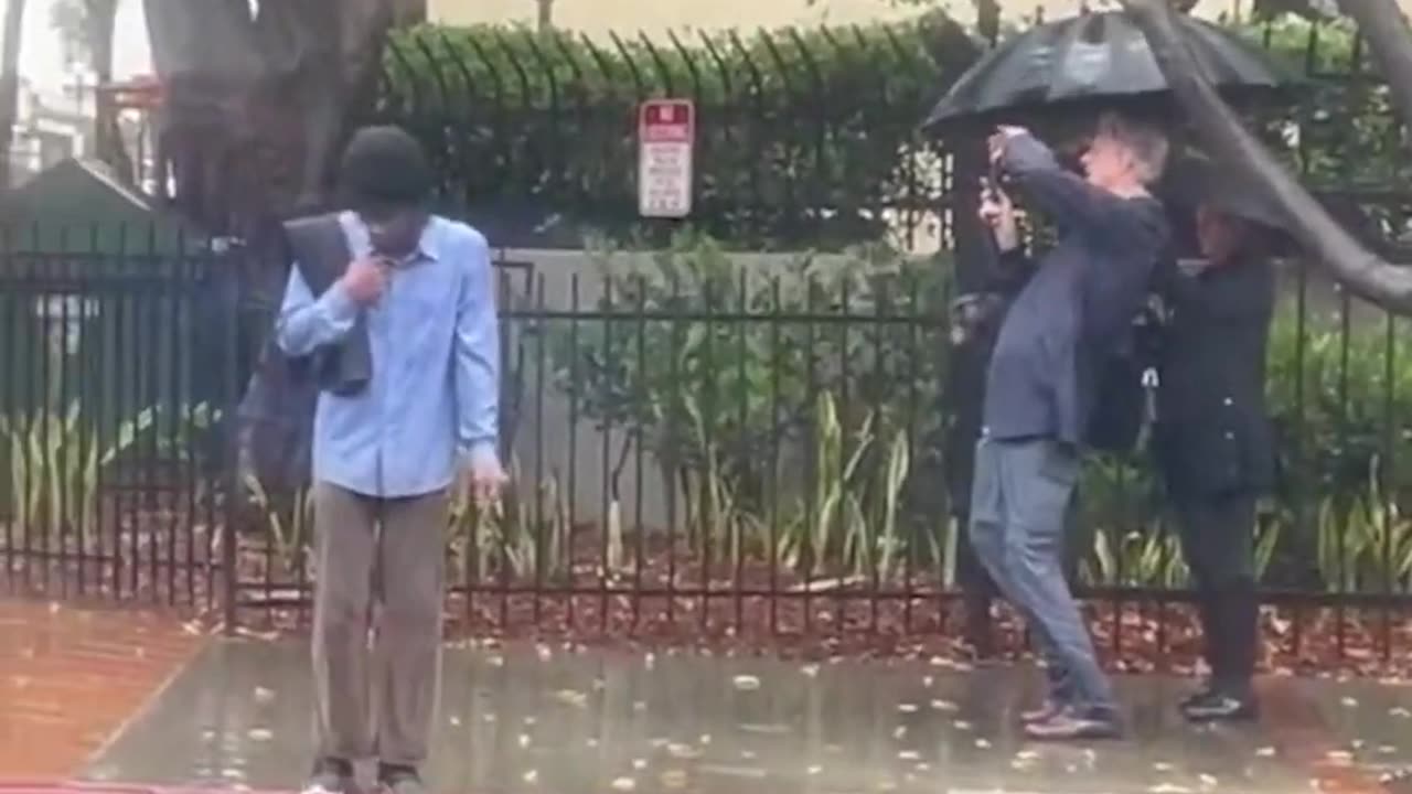 Tall geyser shoots water over multi-story building.