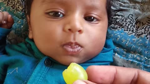 cute baby tasting grapes