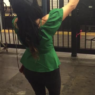 Girl in green shirt dancing in subway station