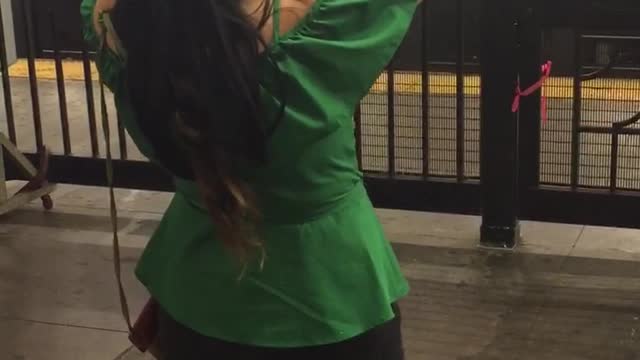 Girl in green shirt dancing in subway station