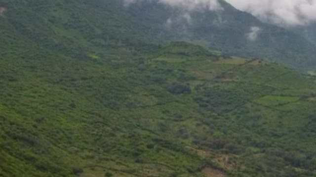 Aerial panorama over a mountainous relief full of vegetation