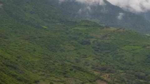 Aerial panorama over a mountainous relief full of vegetation