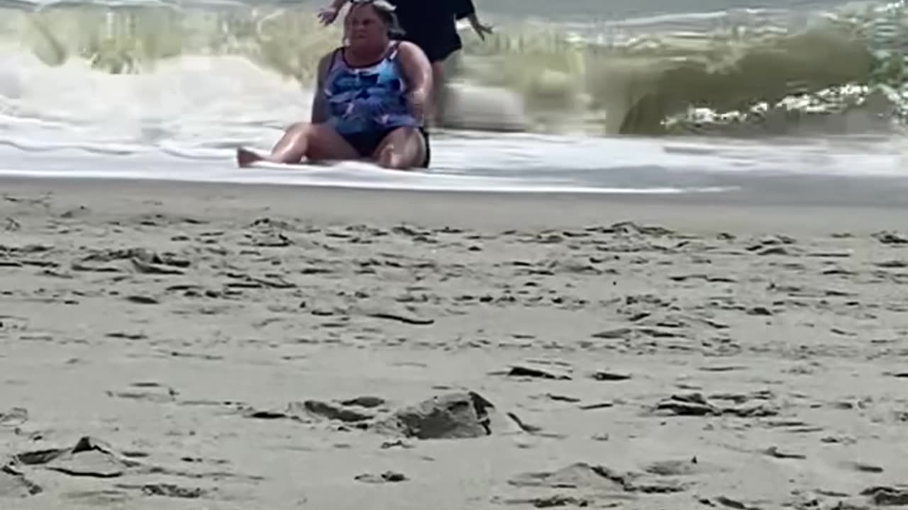 Woman Needs Help Up After Falling at the Beach