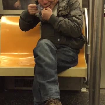 Asian man shaving on subway orange seats
