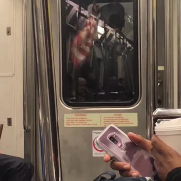 Man with american flag in between subway trains