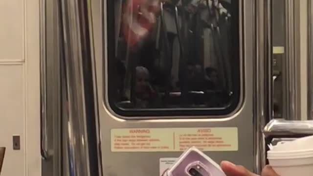 Man with american flag in between subway trains